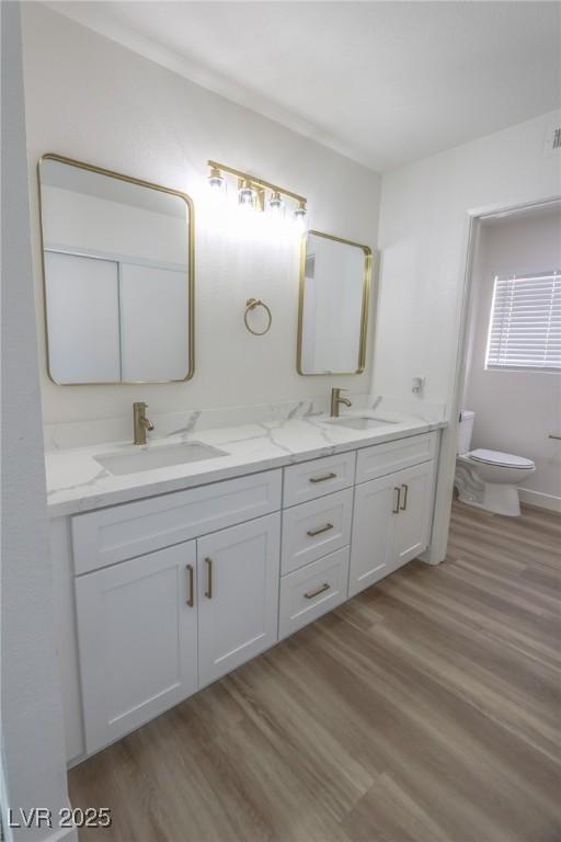 6842 Greengrove Dr, Las Vegas, NV 89103 - bathroom with toilet, wood finished floors, and double vanity