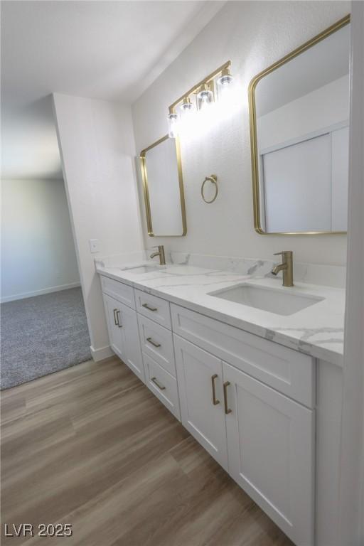 6842 Greengrove Dr, Las Vegas, NV 89103 - bathroom featuring double vanity, wood finished floors, and baseboards