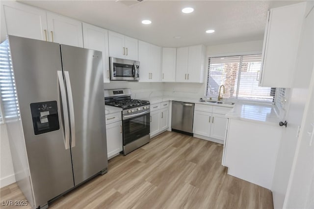 6842 Greengrove Dr, Las Vegas, NV 89103 - kitchen featuring stainless steel appliances, a sink, light wood-style flooring, white cabinets, and recessed lighting