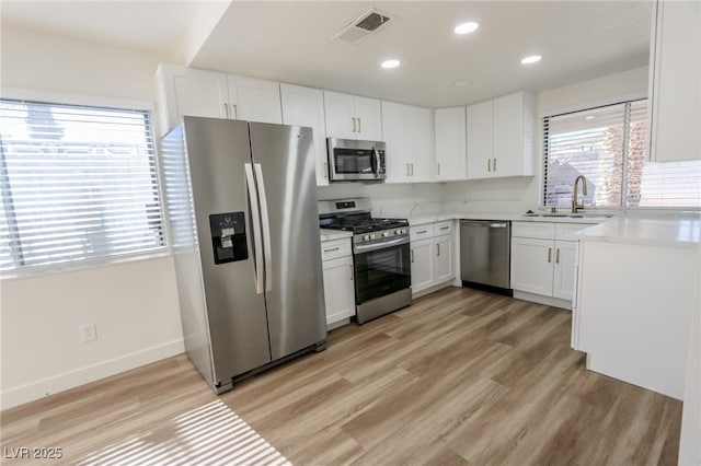 6842 Greengrove Dr, Las Vegas, NV 89103 - kitchen with stainless steel appliances, a sink, light countertops, white cabinets, and recessed lighting