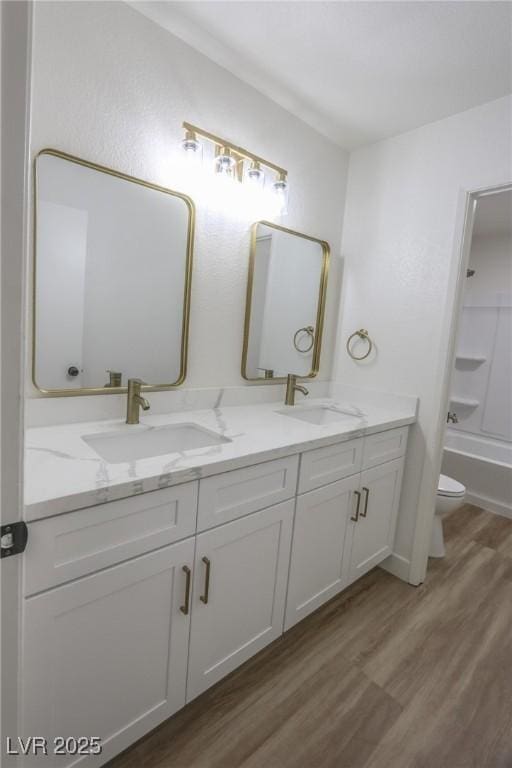 6842 Greengrove Dr, Las Vegas, NV 89103 - bathroom featuring wood finished floors, double vanity, toilet, and shower / tub combination