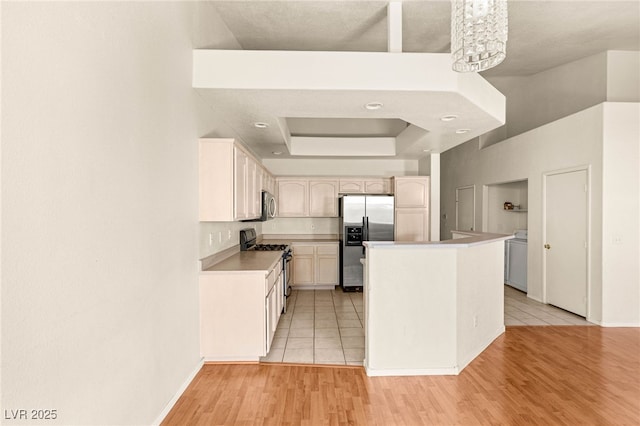 199 Bailey Island Dr, Henderson, NV 89074 - kitchen with appliances with stainless steel finishes, a raised ceiling, light wood-style flooring, light countertops, and baseboards