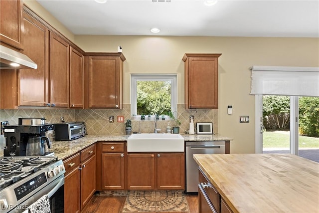 6049 Paddleboat St, North Las Vegas, NV 89031 - kitchen with a sink, stainless steel appliances, butcher block countertops, wood finished floors, and decorative backsplash