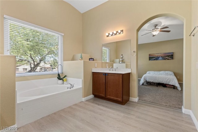 6049 Paddleboat St, North Las Vegas, NV 89031 - bathroom featuring a ceiling fan, a bath, wood finished floors, vanity, and ensuite bathroom