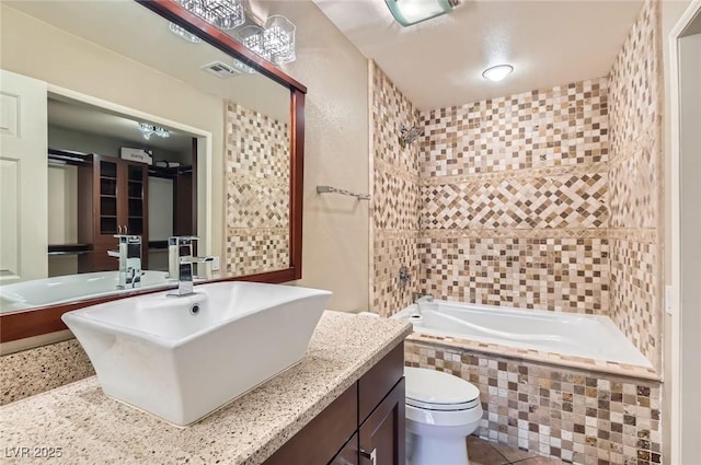 full bathroom with toilet, vanity, and tiled shower / bath