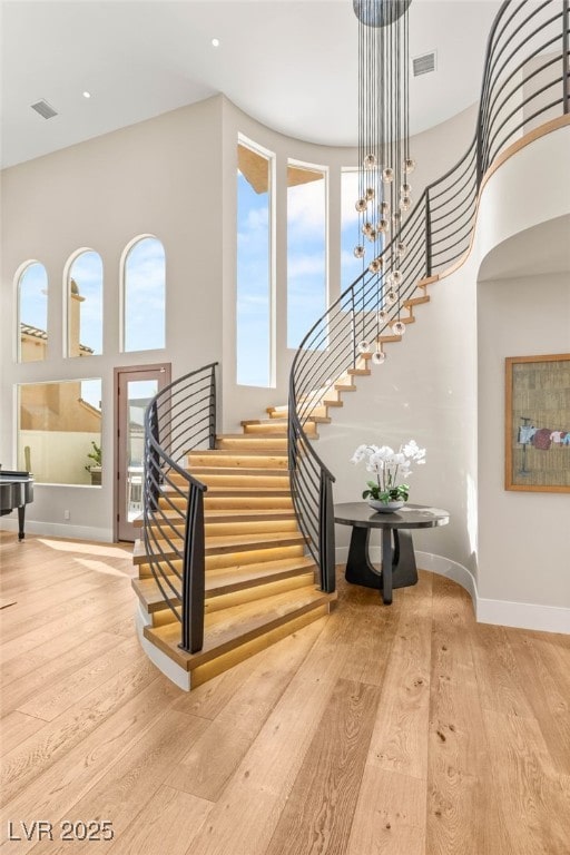 11453 Glowing Sunset Ln, Las Vegas, NV 89135 - foyer with stairs, wood-type flooring, a towering ceiling, and baseboards