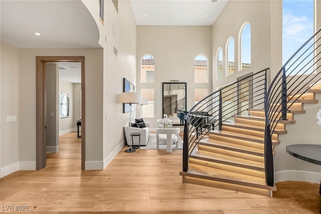 11453 Glowing Sunset Ln, Las Vegas, NV 89135 - stairs featuring wood finished floors, a high ceiling, and baseboards