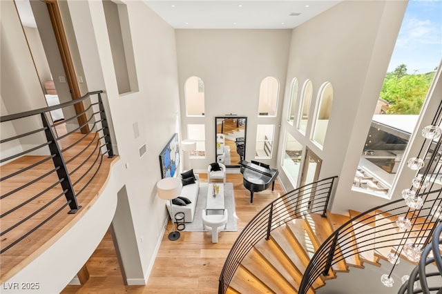 11453 Glowing Sunset Ln, Las Vegas, NV 89135 - stairway featuring baseboards, wood finished floors, a towering ceiling, and recessed lighting