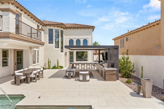 11453 Glowing Sunset Ln, Las Vegas, NV 89135 - rear view of property with stucco siding, a patio area, outdoor dining area, a balcony, and a tiled roof