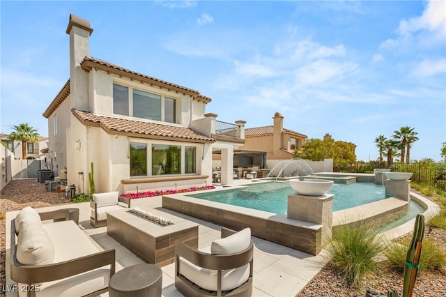 11453 Glowing Sunset Ln, Las Vegas, NV 89135 - back of property featuring a balcony, an outdoor living space with a fire pit, a pool with connected hot tub, and a fenced backyard