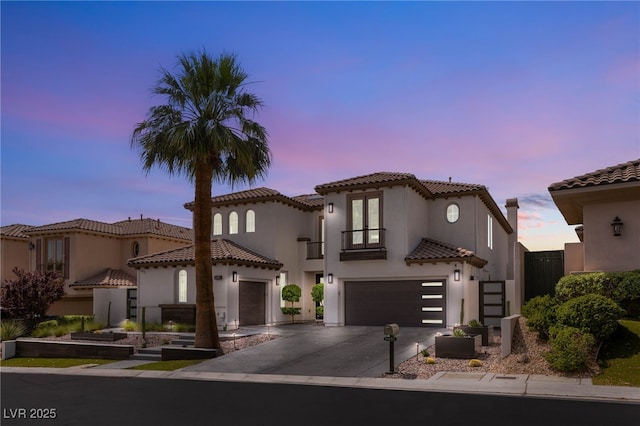 11453 Glowing Sunset Ln, Las Vegas, NV 89135 - mediterranean / spanish-style home with a balcony, concrete driveway, an attached garage, stucco siding, and a tile roof