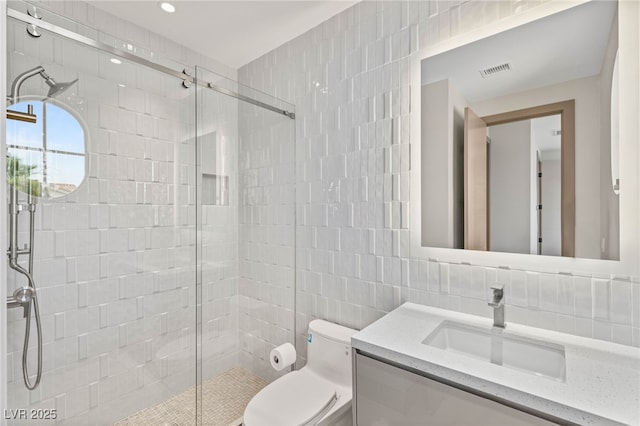 11453 Glowing Sunset Ln, Las Vegas, NV 89135 - bathroom with tile walls, vanity, toilet, and a stall shower