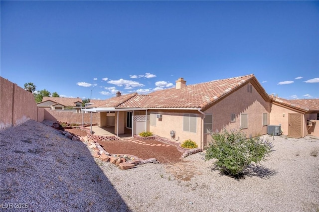 5441 Rose Hills St, Las Vegas, NV 89149 - rear view of house with a chimney, fence, central AC unit, and stucco siding