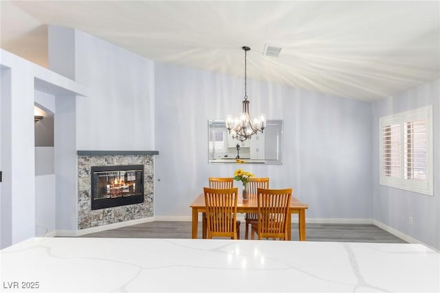 5441 Rose Hills St, Las Vegas, NV 89149 - dining space with wood finished floors, a chandelier, a multi sided fireplace, and baseboards