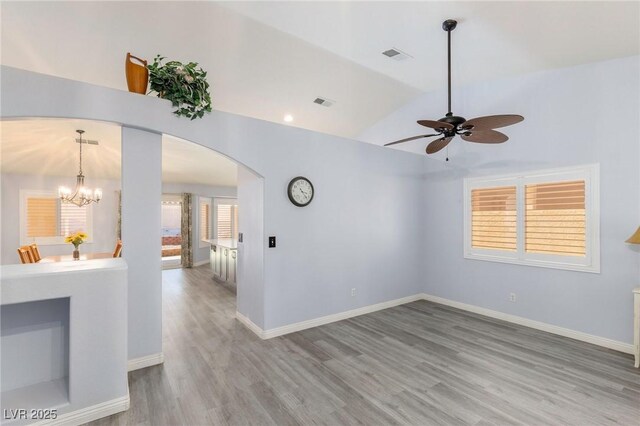 5441 Rose Hills St, Las Vegas, NV 89149 - empty room with arched walkways, wood finished floors, a ceiling fan, a chandelier, and baseboards