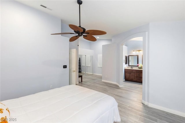 5441 Rose Hills St, Las Vegas, NV 89149 - bedroom featuring light wood-style flooring, baseboards, arched walkways, ensuite bath, and recessed lighting