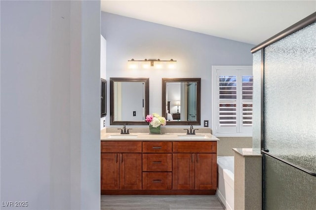 5441 Rose Hills St, Las Vegas, NV 89149 - full bathroom featuring wood finished floors, double vanity, a stall shower, a garden tub, and lofted ceiling