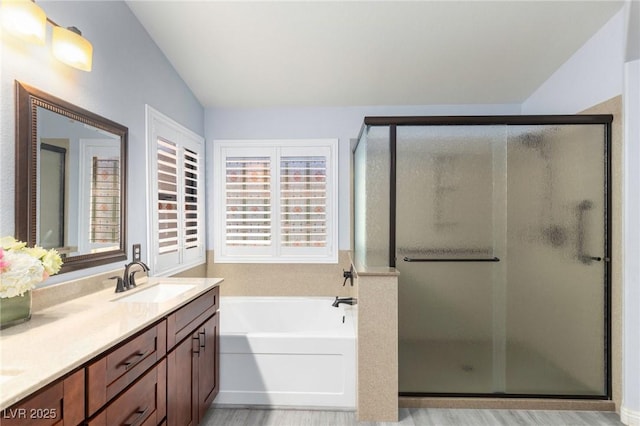 5441 Rose Hills St, Las Vegas, NV 89149 - bathroom featuring lofted ceiling, vanity, a shower stall, a garden tub, and wood finished floors