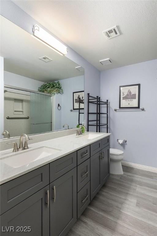 5441 Rose Hills St, Las Vegas, NV 89149 - full bathroom featuring toilet, baseboards, wood finished floors, and double vanity