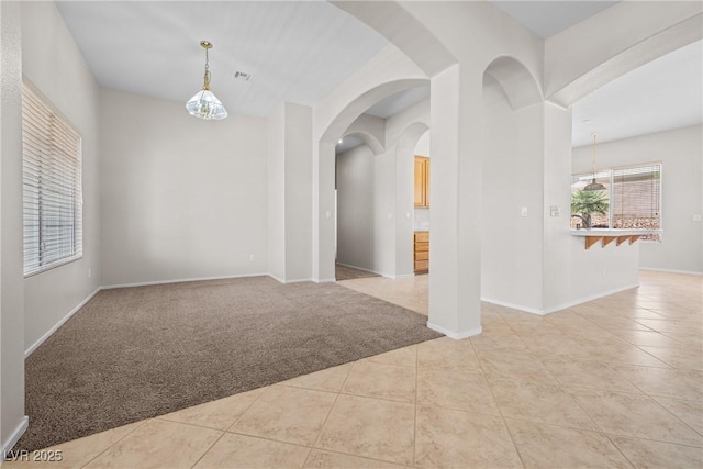 9282 W Viking Rd, Las Vegas, NV 89147 - unfurnished room with carpet, tile patterned floors, baseboards, and arched walkways
