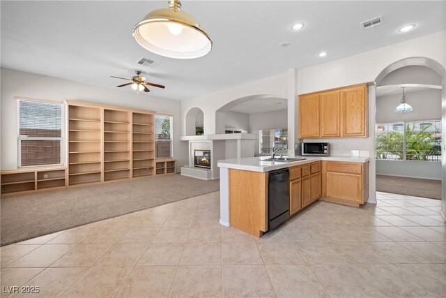 9282 W Viking Rd, Las Vegas, NV 89147 - kitchen with light carpet, dishwasher, stainless steel microwave, a glass covered fireplace, and open floor plan