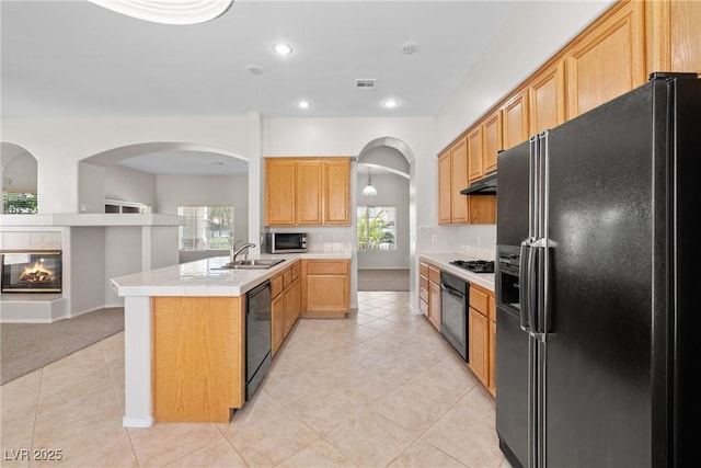 9282 W Viking Rd, Las Vegas, NV 89147 - kitchen with black appliances, a sink, a peninsula, arched walkways, and light tile patterned floors