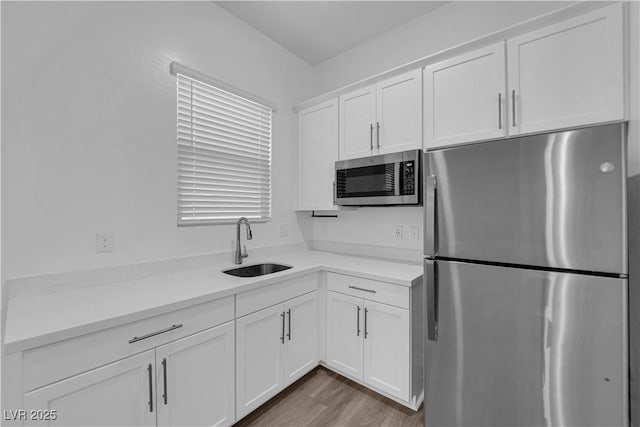 720 Webber Park St, Henderson, NV 89011 - kitchen with appliances with stainless steel finishes, a sink, white cabinets, light countertops, and light wood-type flooring