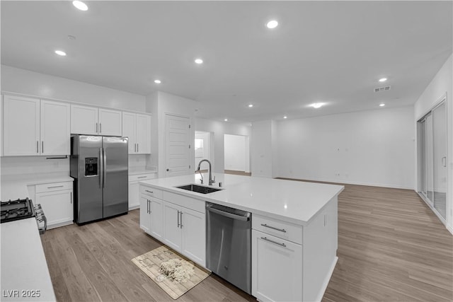 720 Webber Park St, Henderson, NV 89011 - kitchen featuring appliances with stainless steel finishes, a sink, light countertops, an island with sink, and white cabinetry