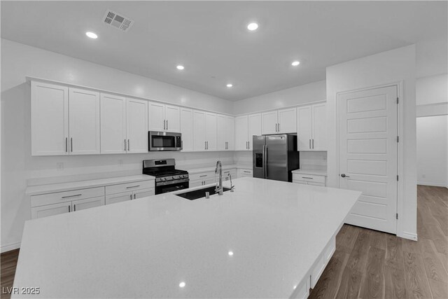 720 Webber Park St, Henderson, NV 89011 - kitchen with appliances with stainless steel finishes, a sink, an island with sink, wood finished floors, and recessed lighting