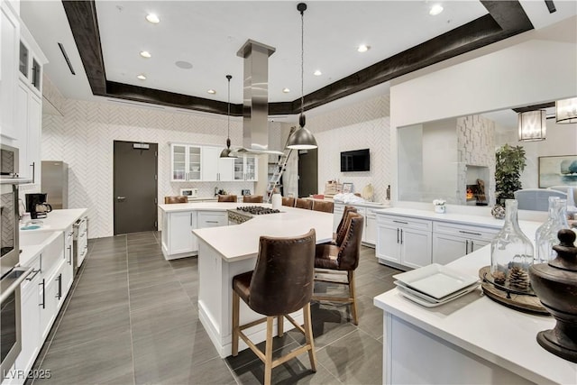 720 Webber Park St, Henderson, NV 89011 - kitchen with wallpapered walls, a raised ceiling, an accent wall, light countertops, and a breakfast bar
