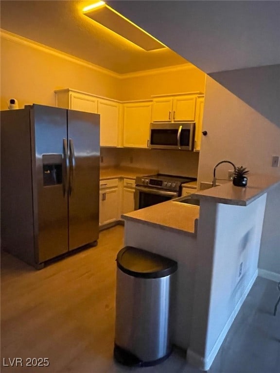 2151 Hussium Hills St Unit 207, Las Vegas, NV 89108 - kitchen with stainless steel appliances, white cabinetry, a peninsula, a sink, and a kitchen breakfast bar