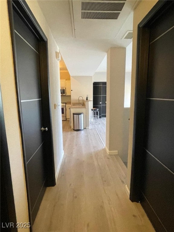 2151 Hussium Hills St Unit 207, Las Vegas, NV 89108 - hallway with light wood-type flooring, a sink, and baseboards
