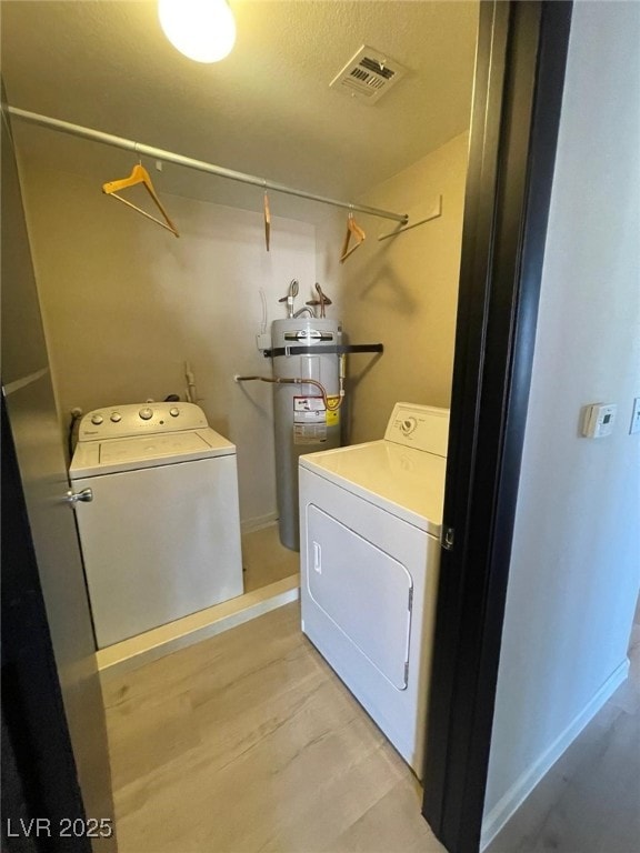 2151 Hussium Hills St Unit 207, Las Vegas, NV 89108 - laundry area with washer and dryer, water heater, light wood-type flooring, and baseboards