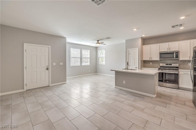 1201 Seaboard Ct, Henderson, NV 89002 - kitchen with stainless steel appliances, light countertops, open floor plan, white cabinets, and recessed lighting