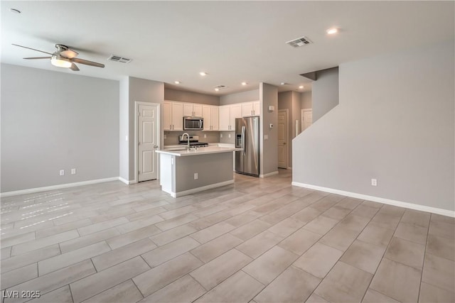 1201 Seaboard Ct, Henderson, NV 89002 - kitchen featuring stainless steel appliances, light countertops, a ceiling fan, open floor plan, and white cabinetry