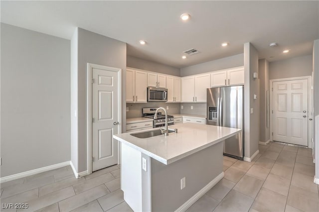 1201 Seaboard Ct, Henderson, NV 89002 - kitchen featuring appliances with stainless steel finishes, a sink, white cabinetry, a center island with sink, and light countertops
