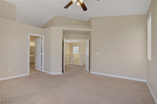 unfurnished bedroom with light colored carpet, baseboards, vaulted ceiling, ceiling fan, and ensuite bath