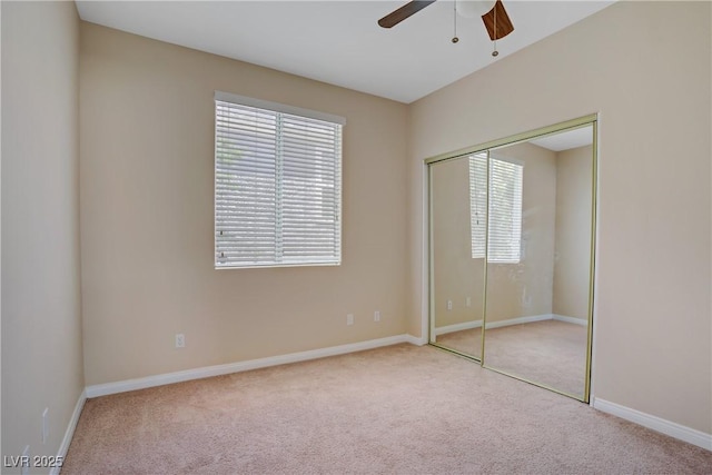unfurnished bedroom with carpet floors, a closet, baseboards, and ceiling fan