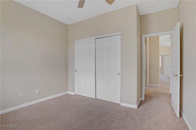 unfurnished bedroom featuring carpet flooring, baseboards, a closet, and ceiling fan