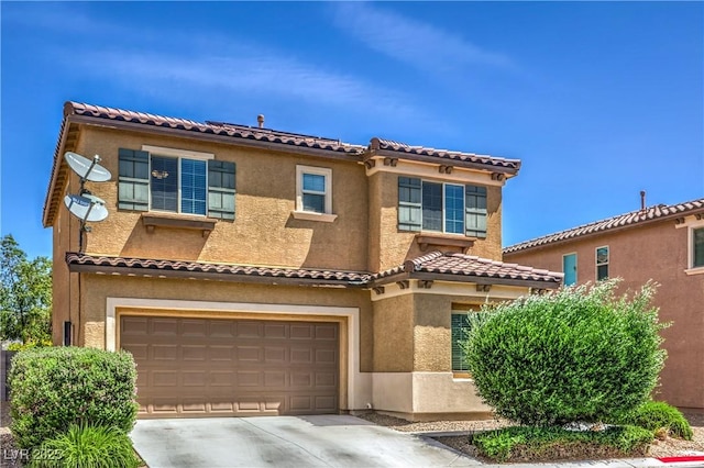 mediterranean / spanish home featuring a garage, stucco siding, concrete driveway, and a tiled roof