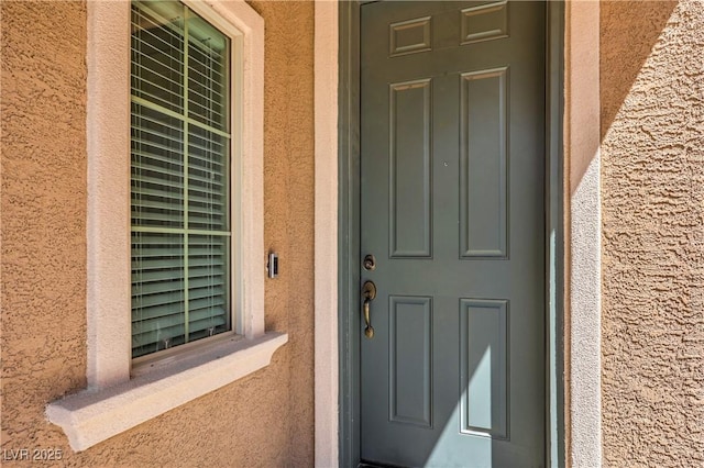 property entrance with stucco siding