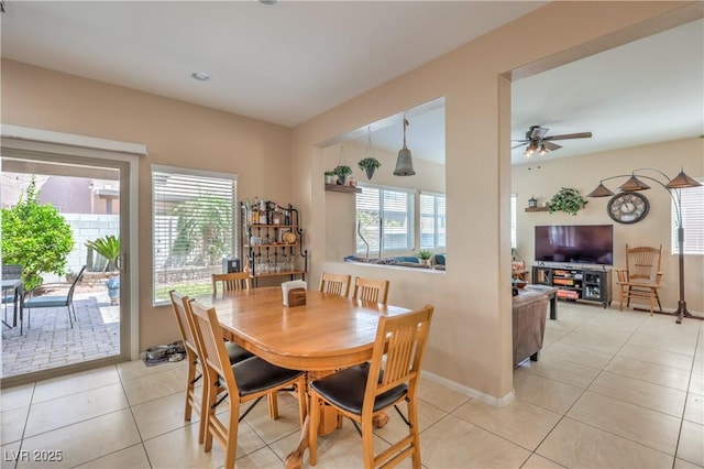 dining area with healthy amount of natural light, a ceiling fan, light tile patterned floors, and baseboards