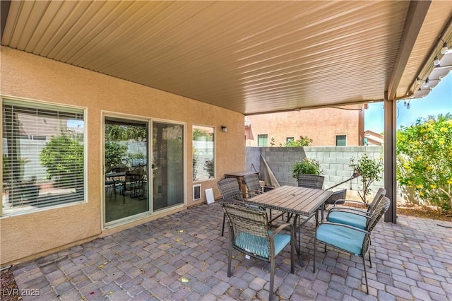 view of patio with outdoor dining area and fence