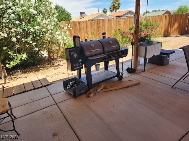 view of patio / terrace featuring fence, a deck, and grilling area