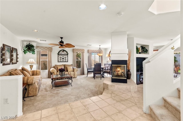 9522 Arrowhead Falls Ct, Las Vegas, NV 89148 - living room with light tile patterned floors, light carpet, stairs, a tiled fireplace, and ceiling fan