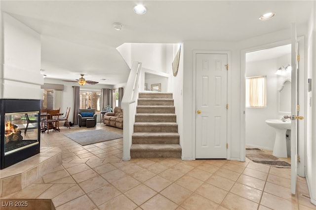 9522 Arrowhead Falls Ct, Las Vegas, NV 89148 - stairs featuring ceiling fan, recessed lighting, tile patterned flooring, and a multi sided fireplace