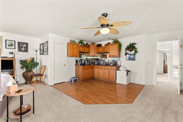 9522 Arrowhead Falls Ct, Las Vegas, NV 89148 - kitchen with a ceiling fan, light carpet, brown cabinets, and dark countertops