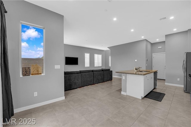 3192 Timorasso Ave, Henderson, NV 89044 - kitchen featuring a sink, white cabinetry, stainless steel appliances, stone counters, and baseboards