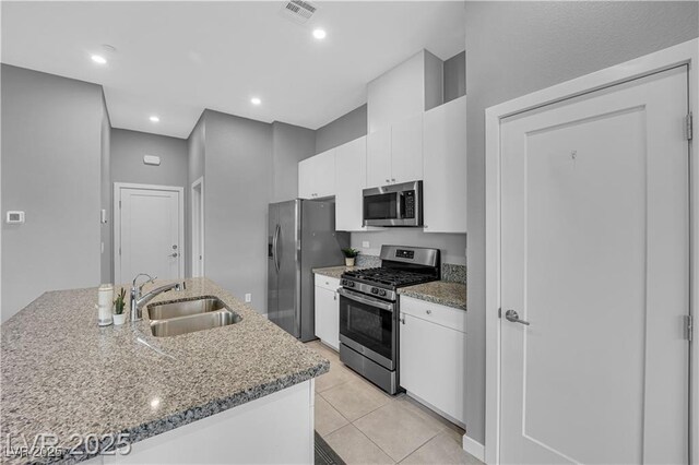 3192 Timorasso Ave, Henderson, NV 89044 - kitchen featuring appliances with stainless steel finishes, a sink, white cabinets, light tile patterned floors, and light stone counters