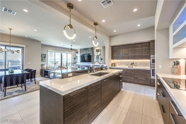 kitchen featuring a sink, modern cabinets, black electric stovetop, light countertops, and recessed lighting